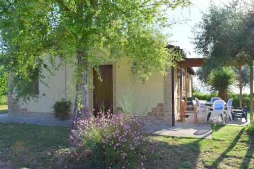 a house with a table and chairs in a yard at Villa Manu in Lapedona
