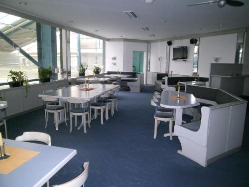 a restaurant with tables and chairs and a tv at Sportpark Jürgen Fassbender in Eggenstein-Leopoldshafen