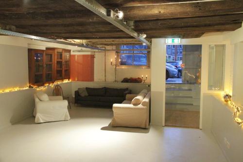 a living room with a couch and chairs in it at Top-notch space along canal in historic centre in Amsterdam