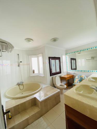 a bathroom with two sinks and a tub and a toilet at Mision Costa in Corralejo