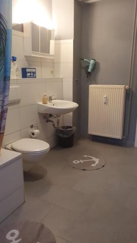 a bathroom with a toilet and a sink at Flensburg Mitte 38 in Flensburg