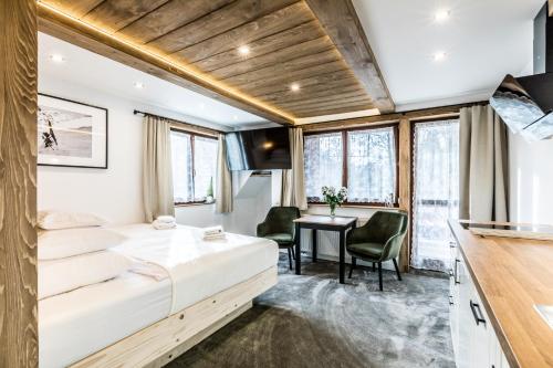 a hotel room with a bed and a desk at Apartamenty Szymaszkowa in Zakopane
