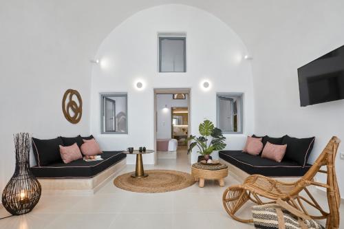 a living room with two couches and a tv at U & ME SUITES in Fira
