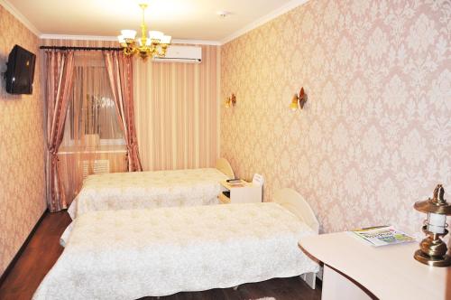 a hotel room with two beds and a table at Evropeyskiy in Kyiv