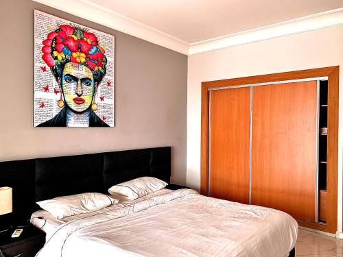 カサブランカにあるAnfa 138 - Best view in town. Great location. Luxurious 2 bedroomsのベッドルーム1室(壁に絵画が描かれたベッド1台付)