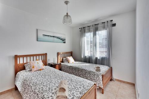 sypialnia z dwoma łóżkami i oknem w obiekcie Casa ERNESTO w mieście Playa Blanca