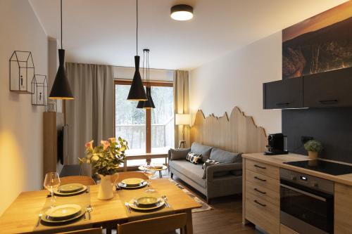 貝德日霍夫的住宿－APARTMÁNY PADESÁTKA - Polední Kameny，厨房以及带桌子和沙发的客厅。