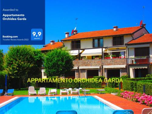 a resort with a swimming pool in front of a building at Appartamento Orchidea Garda in Garda