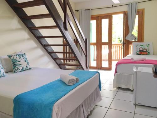a bedroom with two beds and a staircase at Pousada Bicho Preguiça in Itacaré