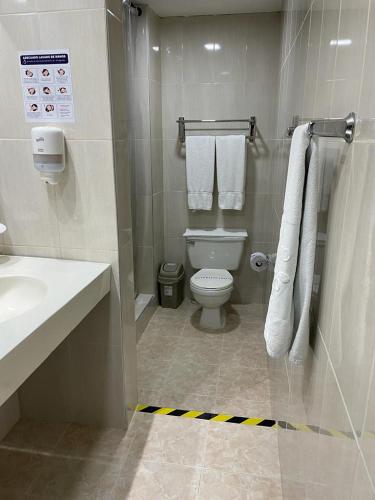 a bathroom with a toilet and a sink and towels at Hotel Camino Real Popayán Colombia in Popayan
