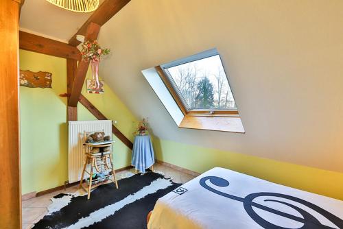 StosswihrにあるLocation Elfeのベッドと窓が備わる屋根裏部屋