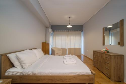 ein Schlafzimmer mit einem großen Bett und einer Kommode in der Unterkunft Athens' Classiest Neighborhood Renovated Apartment in Athen