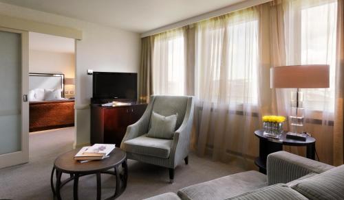 a living room with a couch and a chair and a television at The Bristol Hotel in Bristol