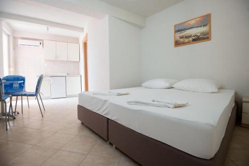 a bedroom with a large bed and a kitchen at Apartments MAMPAS in Neum
