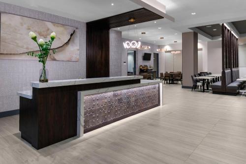 a lobby with a reception counter with a vase of flowers at Hyatt House Charlotte Rea Farms in Charlotte