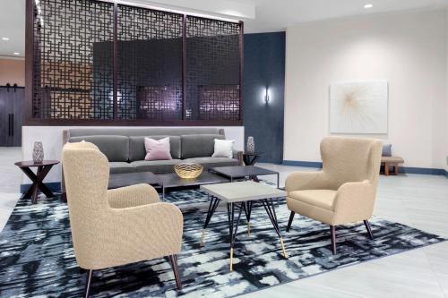 a lobby with a couch and two chairs and a table at Hyatt House Charlotte Rea Farms in Charlotte