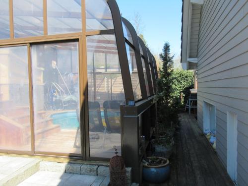 a glass extension to a house with a patio at Le Clos d'Auré. in Oberhaslach