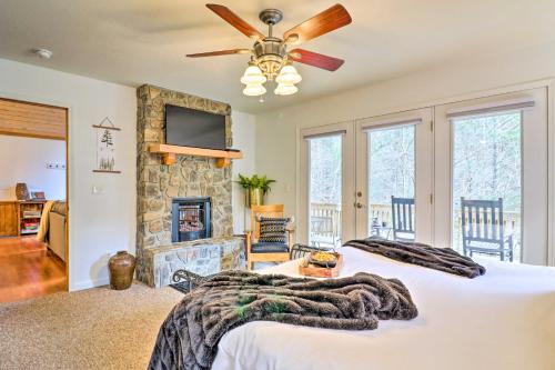 a bedroom with a bed and a stone fireplace at Idyllic Creekside Bryson City Gem with Fire Pit! in Bryson City