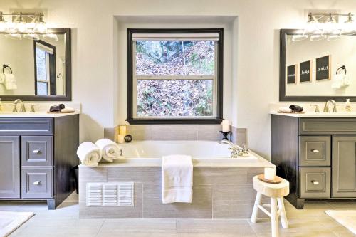 a bathroom with a tub and two sinks and a window at Idyllic Creekside Bryson City Gem with Fire Pit! in Bryson City