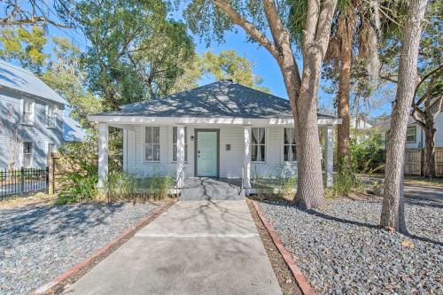 a white house with a blue door and trees at Charming 100-Year-Old Home Less Than 1 Mi to Downtown in Ocala