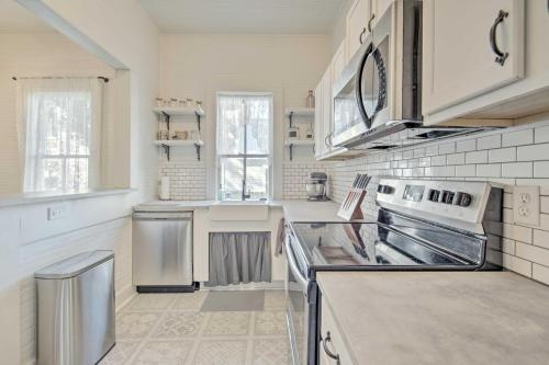 a kitchen with white cabinets and a stove top oven at Charming 100-Year-Old Home Less Than 1 Mi to Downtown in Ocala