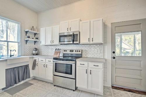 a kitchen with white cabinets and a stove top oven at Charming 100-Year-Old Home Less Than 1 Mi to Downtown in Ocala