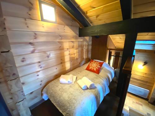 een slaapkamer met een bed in een houten muur bij LE FLOCON 1 Appartement avec terrasse in La Bresse