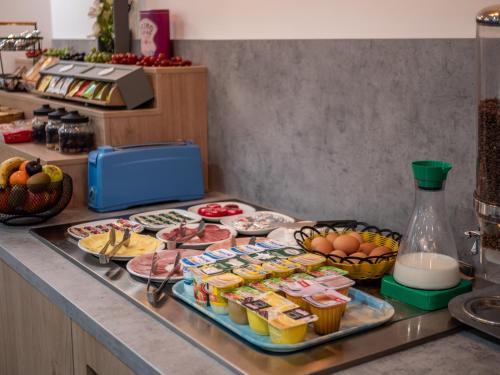 Contact Hotel Bleu France Eragny Cergy في إيرانييه: بوفيه طعام على كونتر في مطبخ