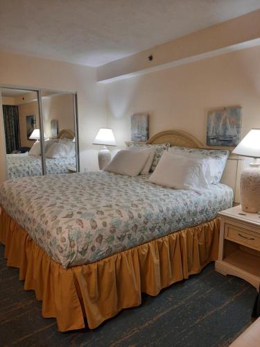 a bedroom with a large bed with two lamps and a mirror at A Happy Seashell Story in Daytona Beach