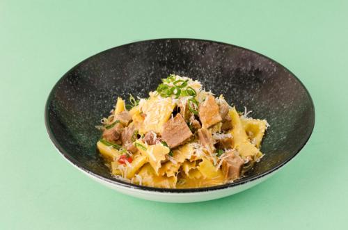 a black bowl of food with meat and cheese at Lush Motel Ipiranga in Sao Paulo