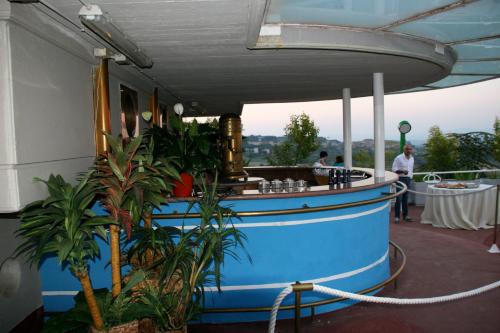 a boat bar on a deck with plants and people at Hotel President in Chianciano Terme