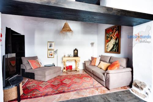 a living room with two couches and a fireplace at Vivienda Vacacional El Patio de Franky in Teguise