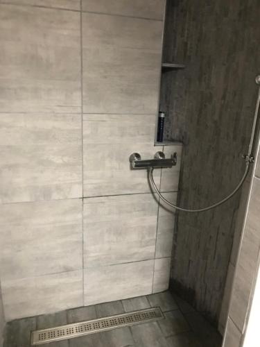 a shower with a hose attached to a wall at Le Clos d'Auré. in Oberhaslach