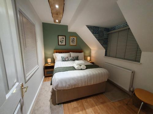 a bedroom with a large bed in a attic at Riverwood Retreat - Self Contained Lux Apartment, Close to the Celtic Resort in Kemeys Inferior