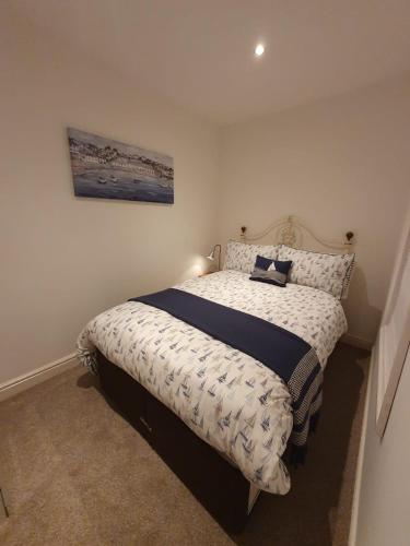 a bedroom with a bed with a comforter on it at Riverwood Retreat - Self Contained Lux Apartment, Close to the Celtic Resort in Kemeys Inferior