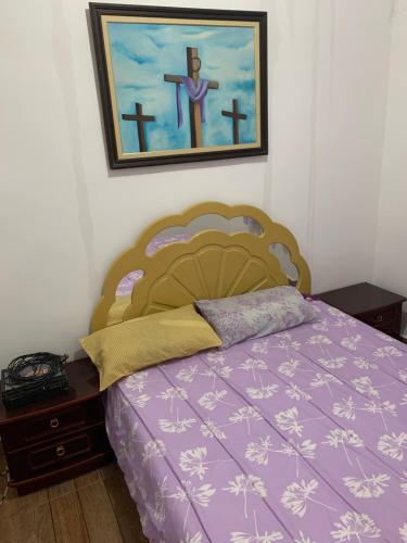 um quarto com uma cama roxa e um quadro na parede em Casa - Praia do Arrastão SS em São Sebastião