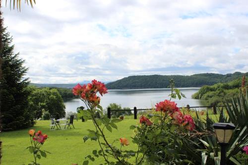 a view of a lake with flowers in the foreground at Agroturismo Atxarmin in Elosu