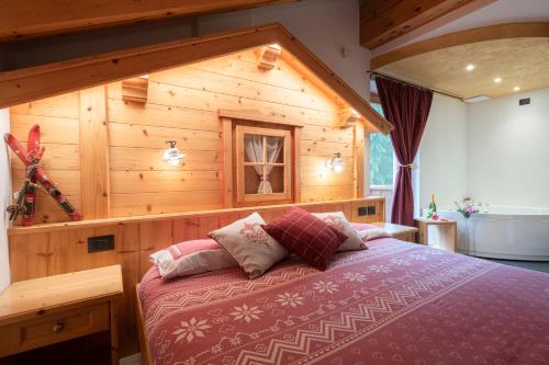 - une chambre avec un lit dans une pièce en bois dans l'établissement Baita Velon, à Vermiglio