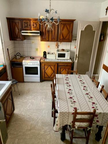 une cuisine avec une table recouverte d'une nappe dans l'établissement Gîte de l’Allaine, à Morvillars