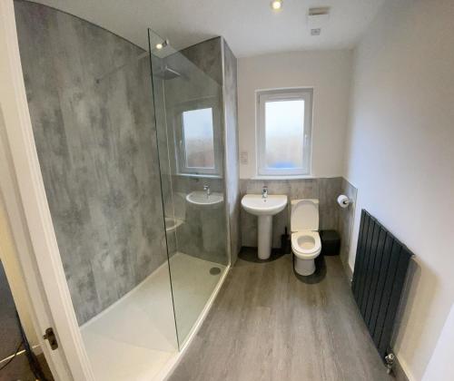 uma casa de banho com um chuveiro, um WC e um lavatório. em Holm from Home em Inverness
