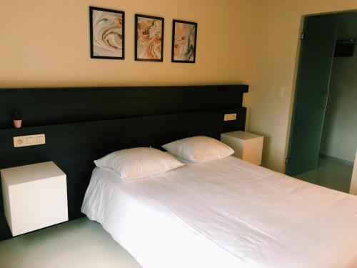 a bedroom with a large bed with two pillows at Auberge du Vieux Cedre, Enghien-Belgique in Enghien