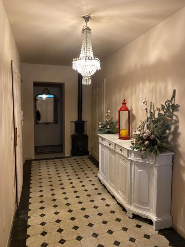 un corridoio con lampadario pendente e una stanza con tavolo di La Didì Maison a Bologna