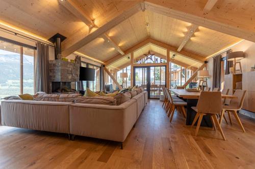 a living room with a large couch and a table at Bergresort Hauser Kaibling by ALPS RESORTS in Haus im Ennstal