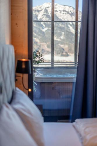 a bedroom with a bed and a window with snow at Bergresort Hauser Kaibling by ALPS RESORTS in Haus im Ennstal