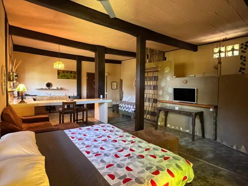 Villas Adriana, Palenque في بالينكو: غرفة نوم مع سرير وغرفة معيشة