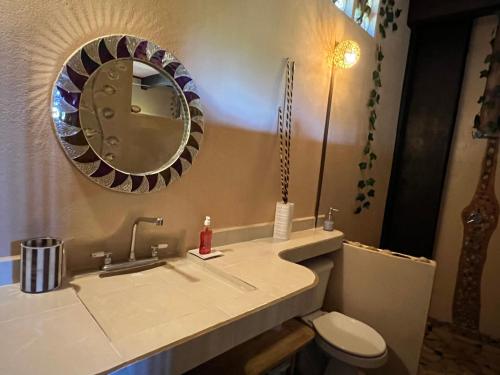 a bathroom with a sink and a toilet and a mirror at Villas Adriana, Palenque in Palenque