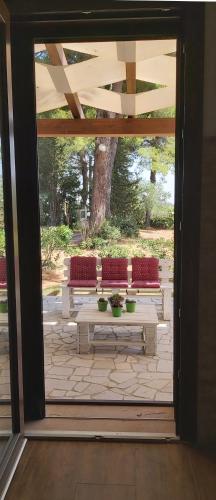 an open door to a patio with two benches at Villa del Sole in Manduria