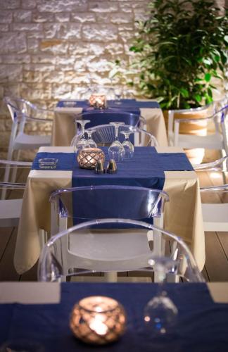 a table with blue tables and chairs with plates and glasses at Melina Bay Boutique Hotel in Kassiopi