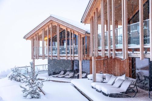 a house in the snow with snow covered furniture at Bergresort Hauser Kaibling by ALPS RESORTS in Haus im Ennstal