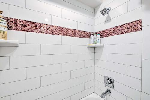 a white tiled shower with red accent tiles at Vibrant Chic Home about 20 Mi to Salt Lake City! in Draper